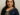 Alt text: Rani Mukerji smiling in a navy blue sari with golden embroidery, holding her National Film Award trophy against a plain background.